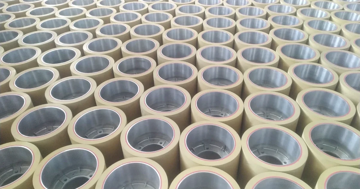 Rows of finished yellow rice rubber rollers with steel cores lined up in a factory, rubber rollers ready for dispatch